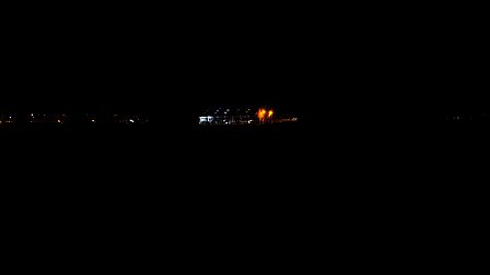 Stal aan de Dronkelaarseweg in Terschuur in de late avond. Door zijn verlichting is de stal van verre zichtbaar in het verder open en donkere landschap