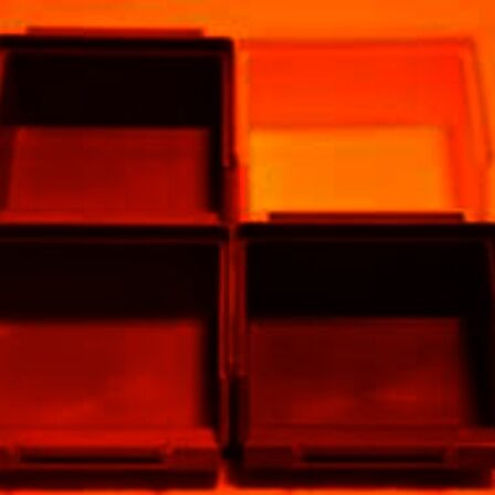 Gekleurde bakjes die verlicht worden met oranje licht, alles lijkt rood/oranje