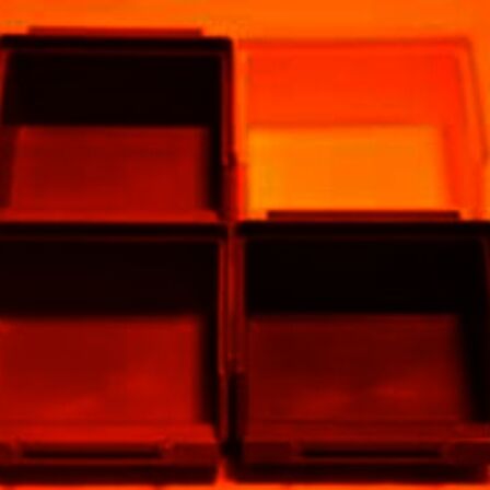 Gekleurde bakjes die verlicht worden door oranje licht, alles lijkt rood/oranje