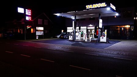 Kootwijkerbroek, tankstation in het donker. Het tankstation is verplicht, ook de naam van het bedrijf. Ernaast hangt een verlicht reclamebord aan een lantaarnpaal. Dit bord is niet meer leesbaar en erg licht. Daardoor lijkt het donker op straat. Door in overleg te gaan kan het wellicht anders