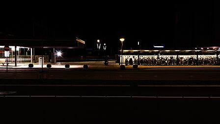 Station Barneveld Centrum ’s avonds laat. De fietsenstalling en wachtruimte zijn verlicht door ProRail, ook staan er lantaarnpalen. Deze vallen weg door het felle licht van ProRail